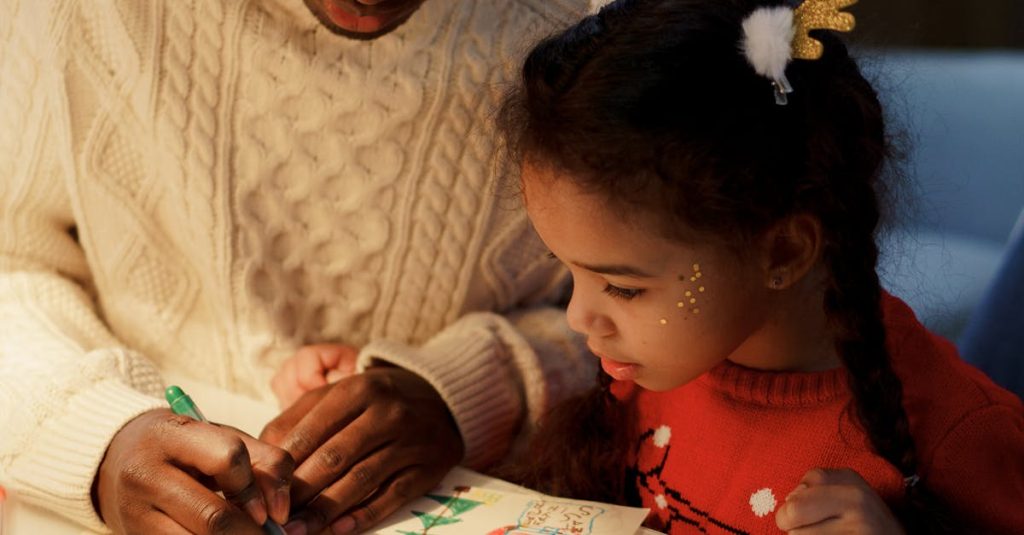 Father and daughter enjoying quality time crafting a Christmas letter with colorful materials.